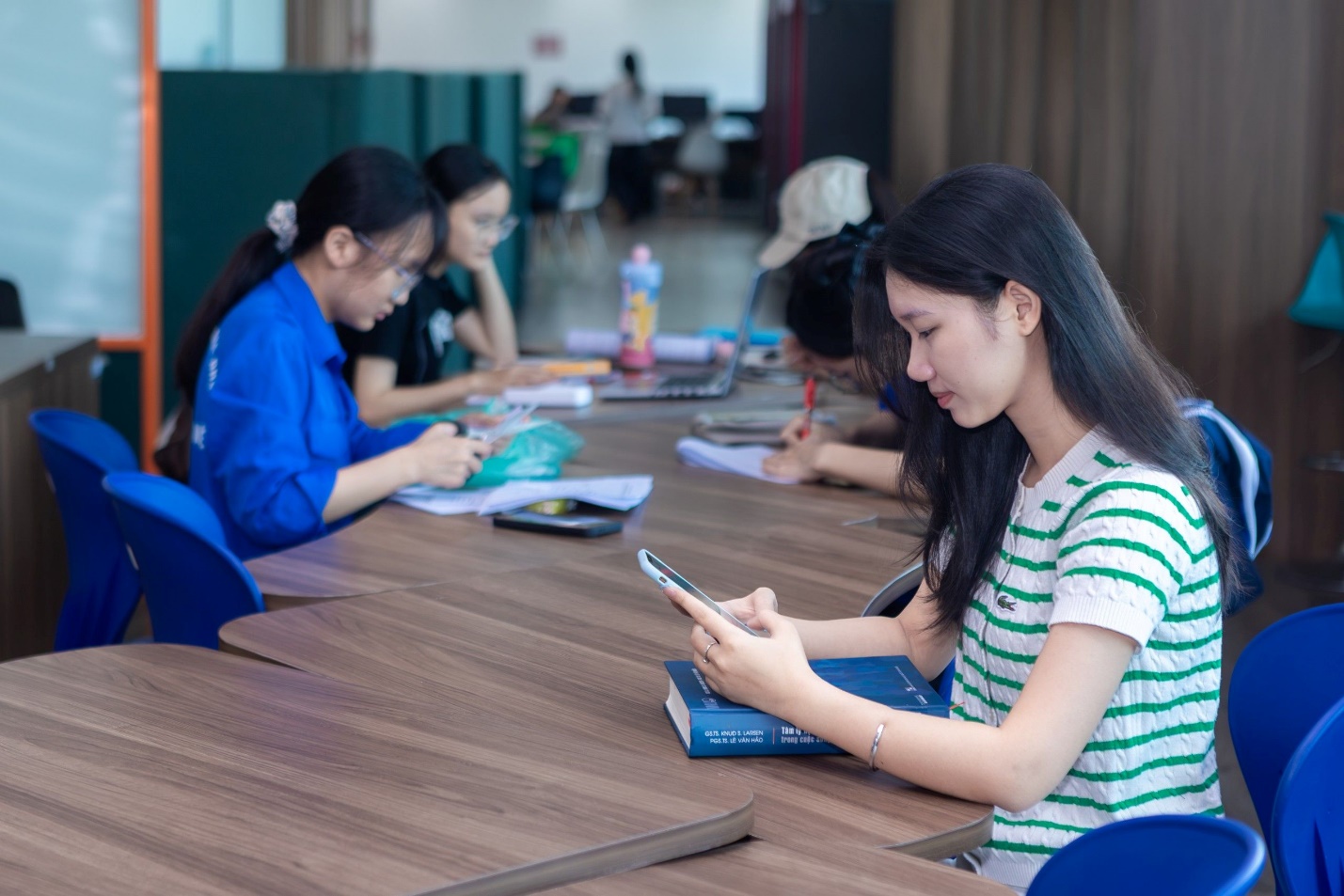 Young customers using smartphones in a shared study space